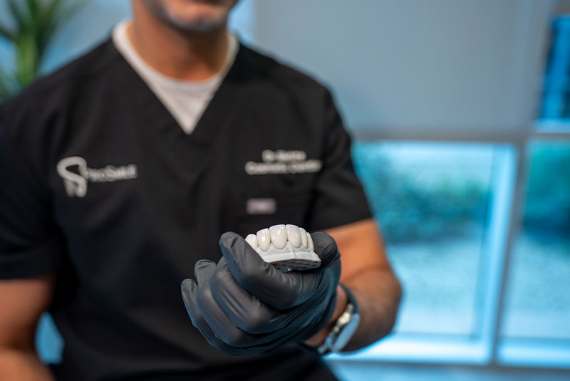 Doctor holding up model of teeth