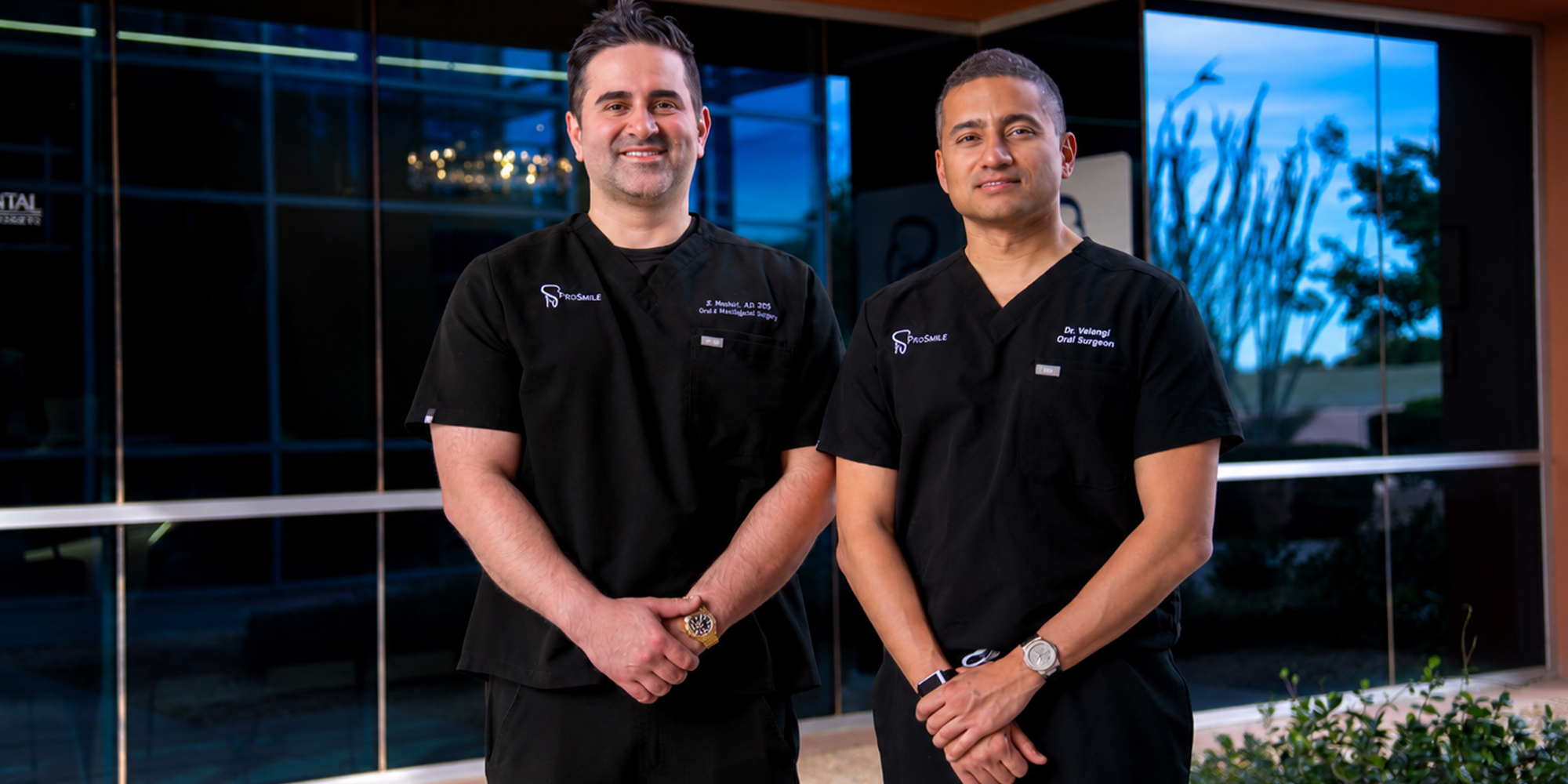 both doctors standing in front of the office smiling with hands crossed
