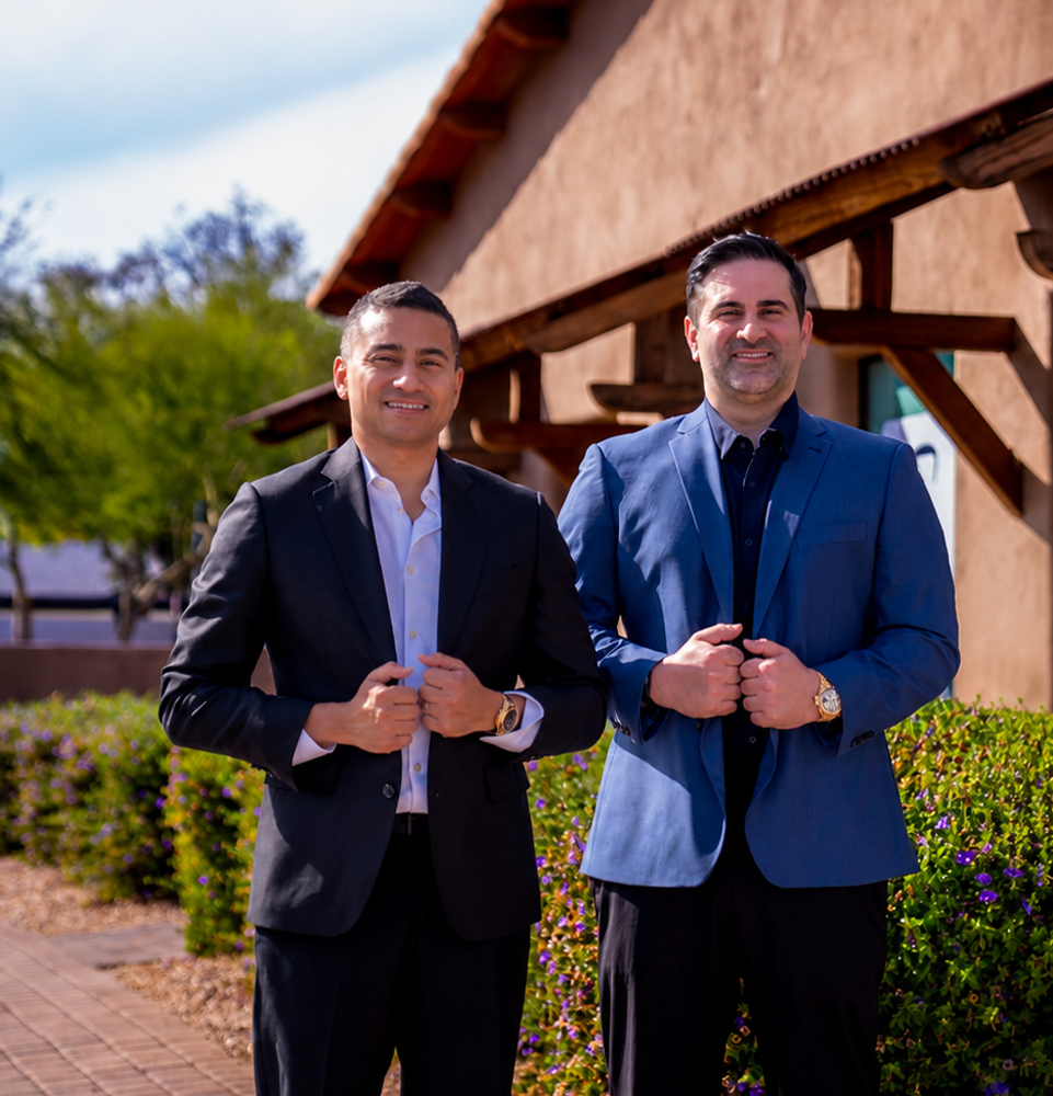 both doctors standing outside of the office and smiling